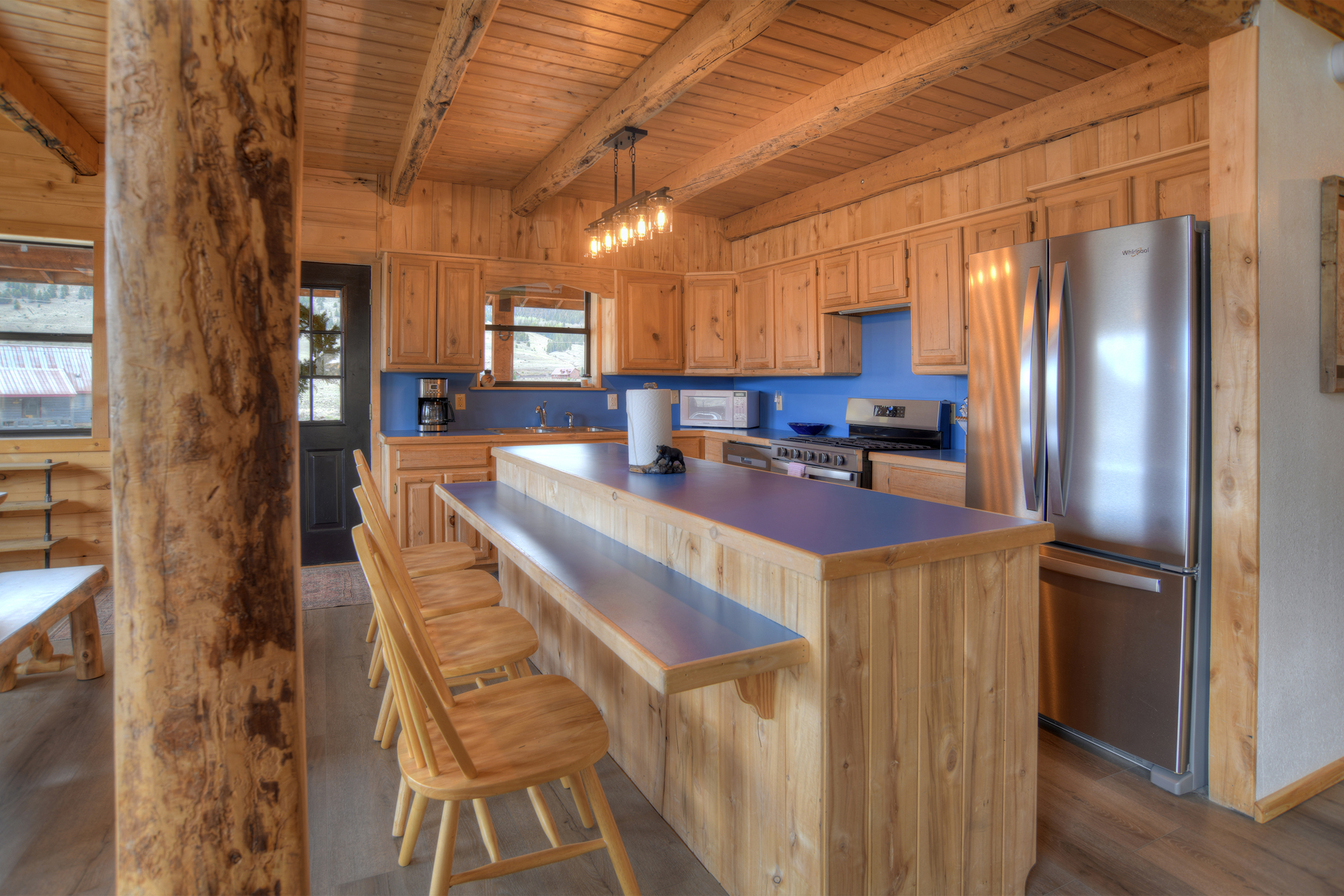 Open-concept living area featuring a fully equipped kitchen with stainless steel appliances, and a dining area with plenty of seating.