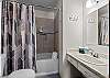 Full bathroom with convenient tub/shower combo and modern finishes.
