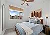Second bedroom features a Queen bed with an overhead fan and Smart TV