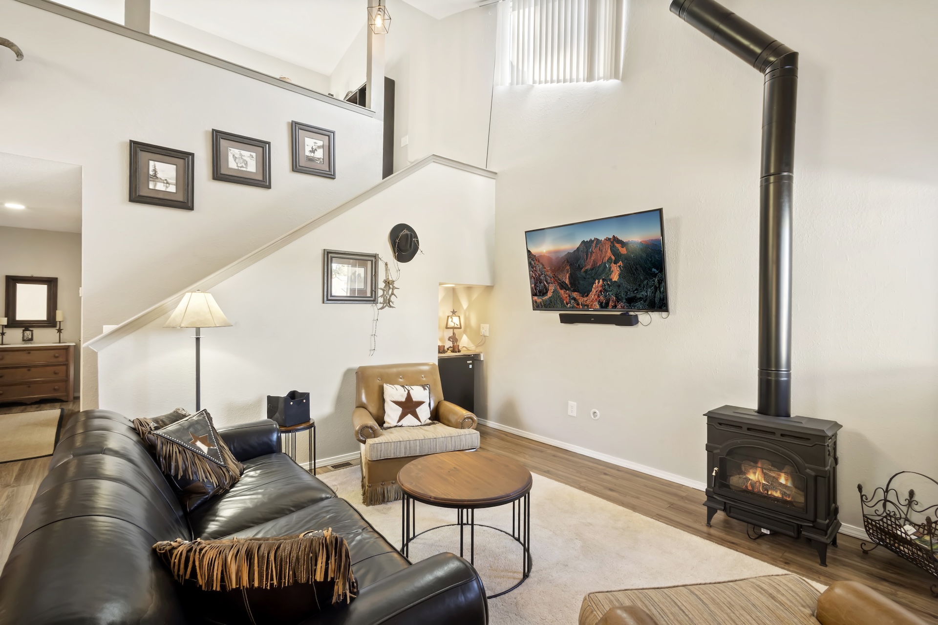 Living room with gas fireplace, smart TV and mini fridge. Open to kitchen and dining.