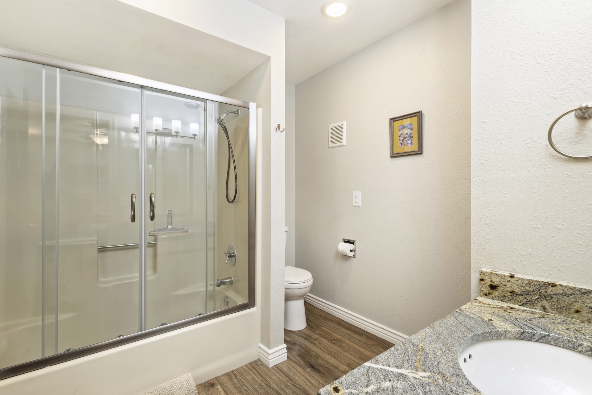 Main level king bedroom ensuite bathroom with tub/shower combo and granite countertops.