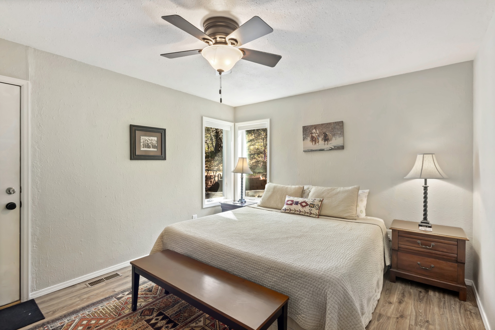 Main level king bedroom with Smart TV, ensuite bathroom and back patio access.
