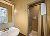 Full bathroom featuring a sleek walk-in shower and soaking tub.
