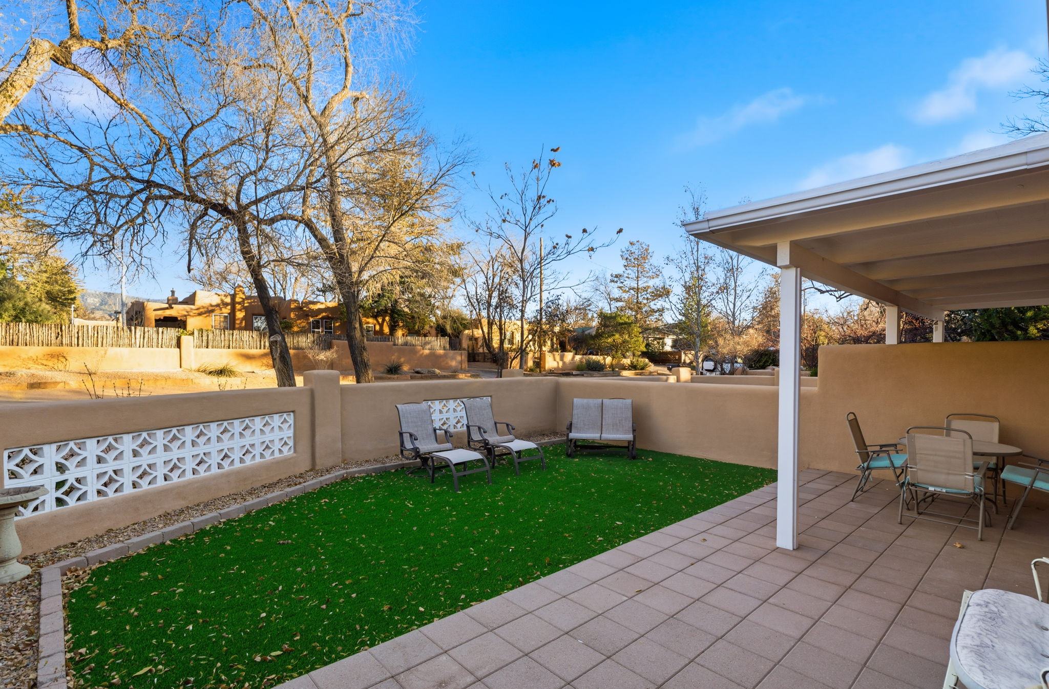 Fully fenced yard with multiple outdoor seating areas 
