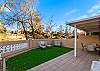 Fully fenced yard with lush grass and multiple outdoor seating areas for total privacy