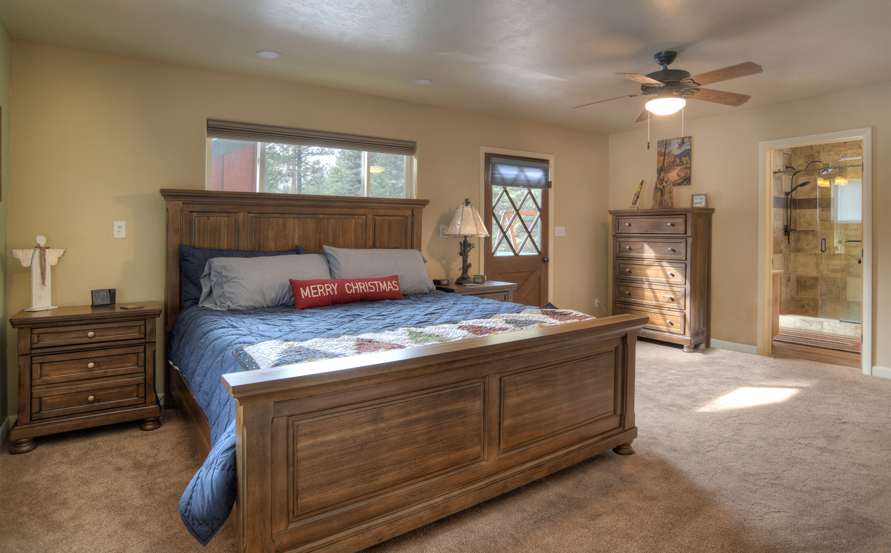 Spacious guest bedroom with king bed and abundant natural light from windows.