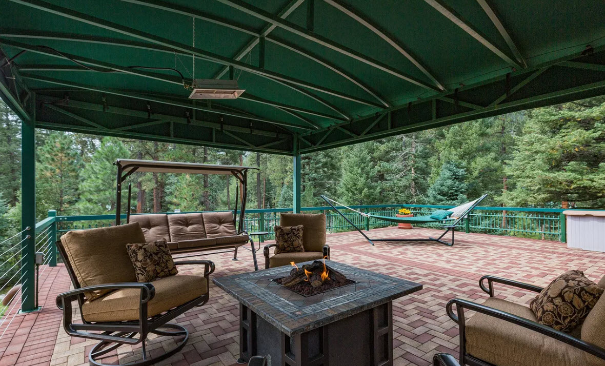 Rooftop deck with fire pit and comfortable seating for sunset and stargazing.