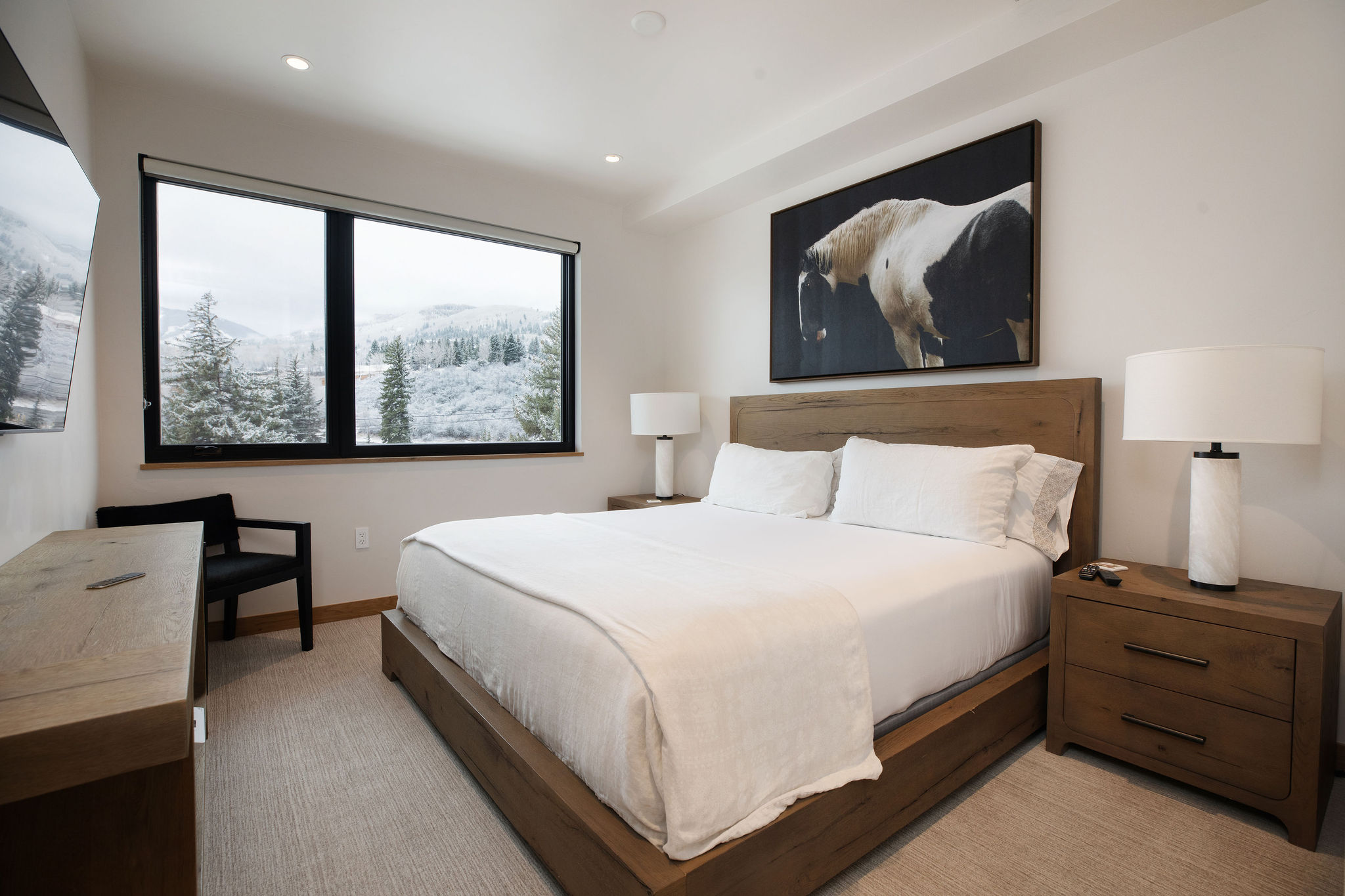 Spacious king bedroom with plush bedding, modern style, and peaceful mountain-home ambiance