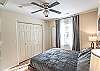 King bedroom #2 with an overhead fan and blackout curtains for a restful night's sleep.