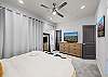 Clean modern bedroom with neutral tones and ceiling fan for year-round comfort