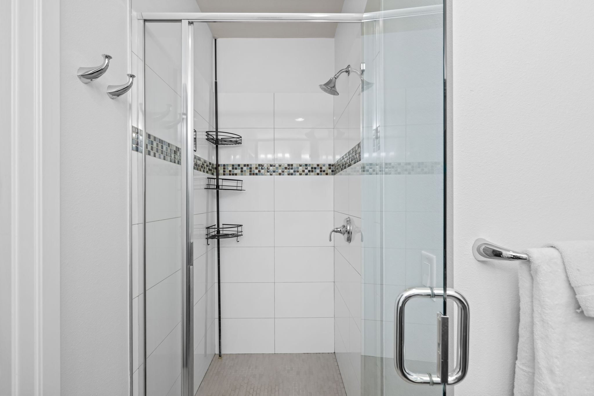 Walk-in shower with modern tile work in one of three ensuite bathrooms