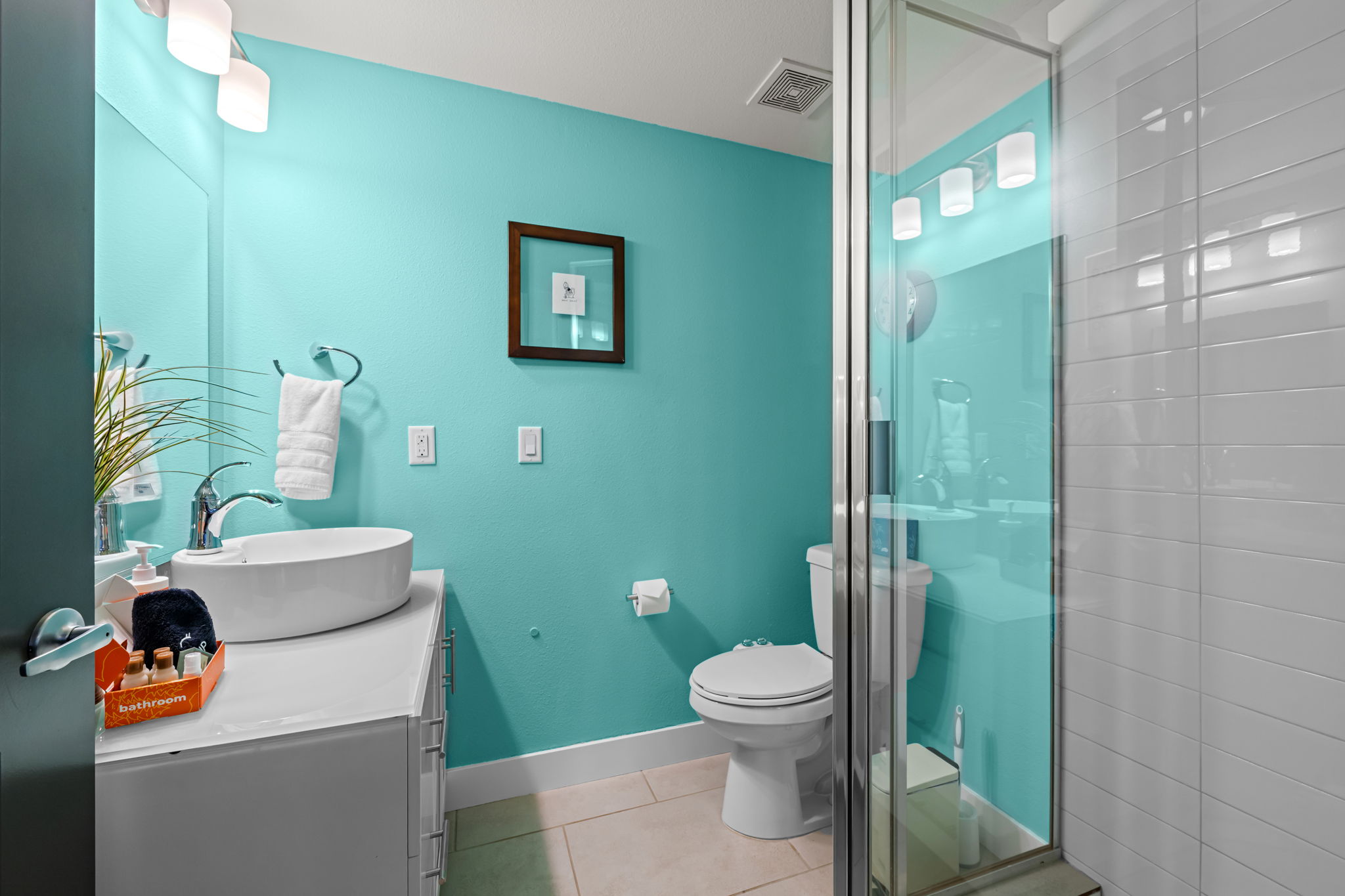 Bright turquoise bathroom with tub-shower combo—stylish and modern finishes