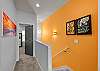 Bright interior hallway with vibrant accent wall and artwork