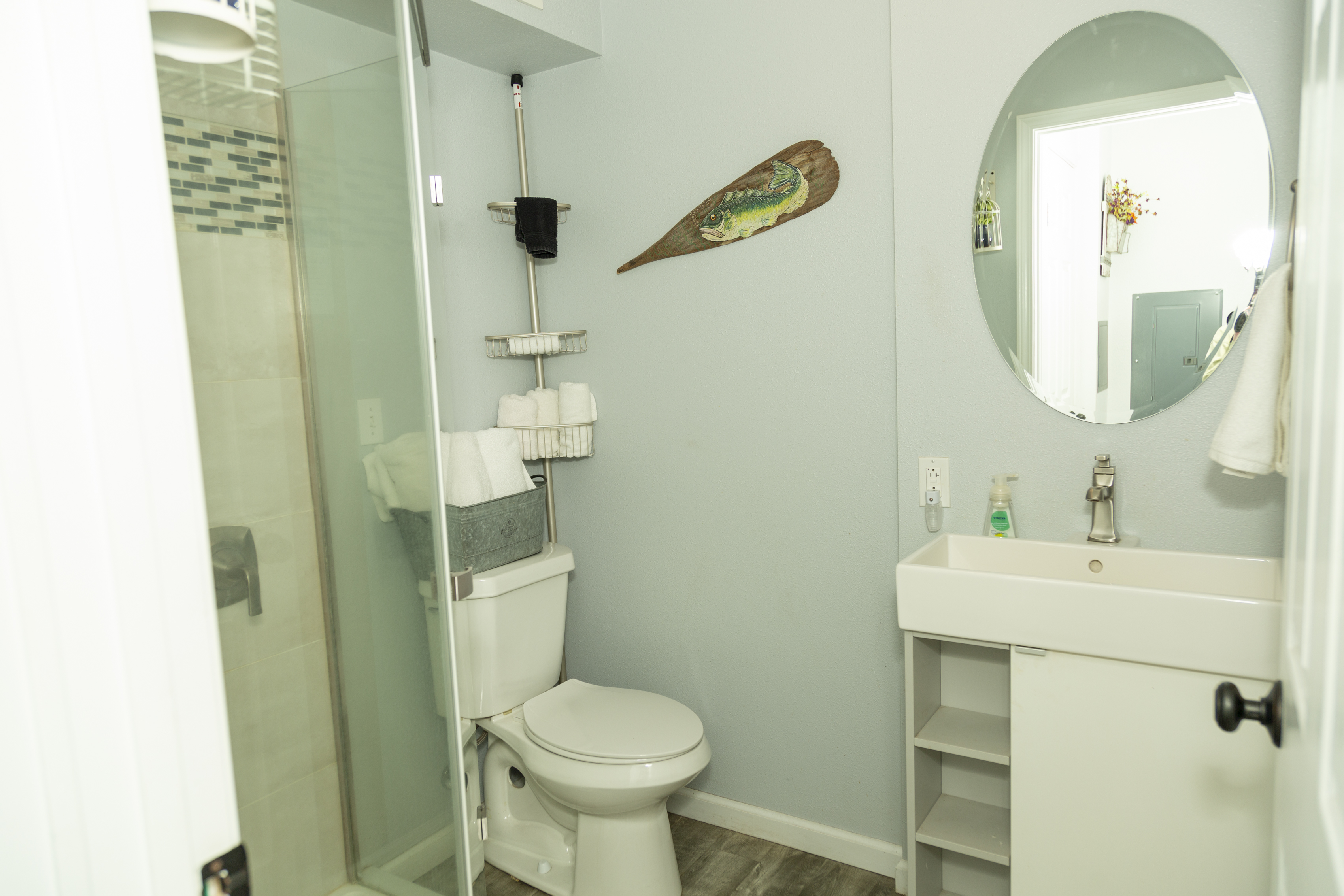 Updated bathroom with fresh fixtures and vintage-inspired details.Exterior stairs and entry providing access to upper-level units.Exterior view showing deck, walkway, and piExterior staircase with fall foliage and access to upper units.ne tree landscaping