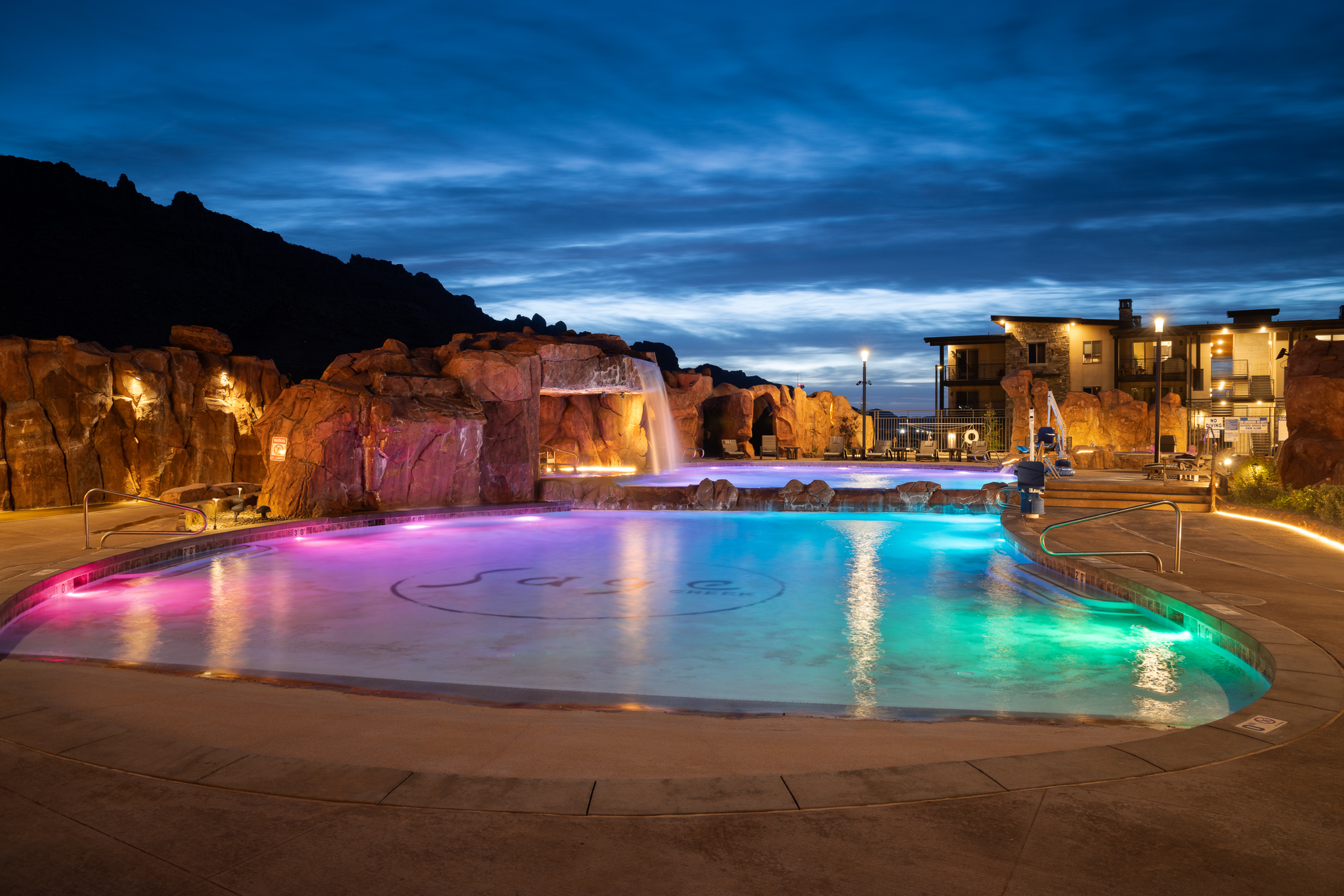 Evening pool scene with dramatic lighting and stunning La Sal Mountain views.