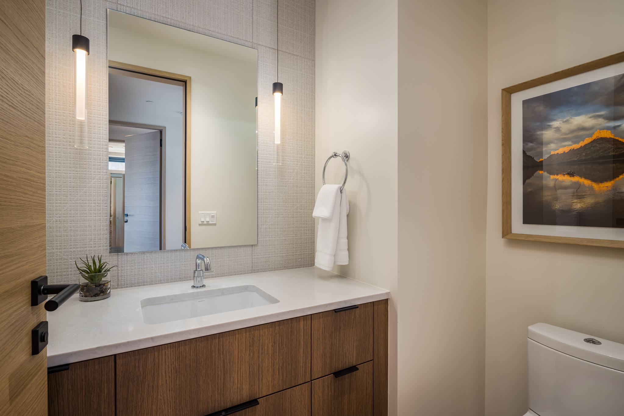 Conveniently located half bath with sleek sink and toilet
