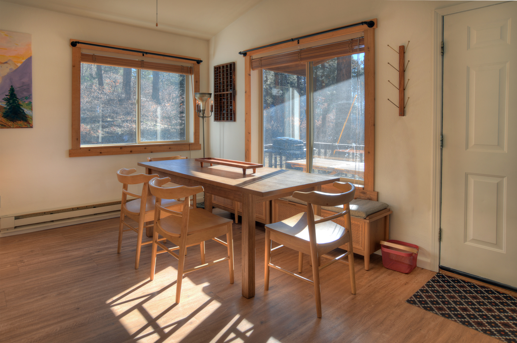Sunny living and dining room with large windows framing mountain views – feel connected to nature while enjoying the comforts of home.