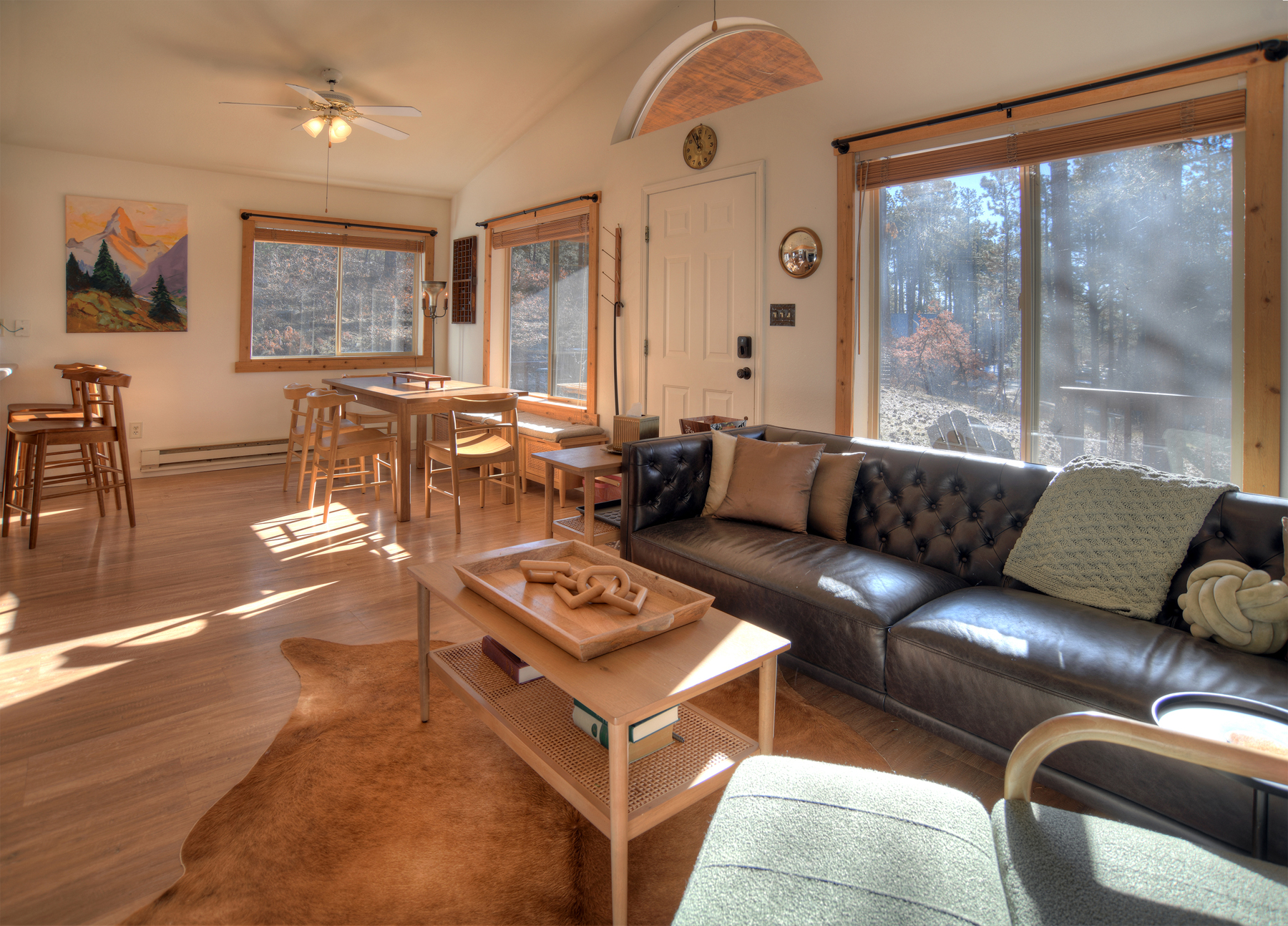 Inviting living and dining area with natural wood finishes – gather around the table for meals or relax by the warm fireplace on cool mountain evenings.