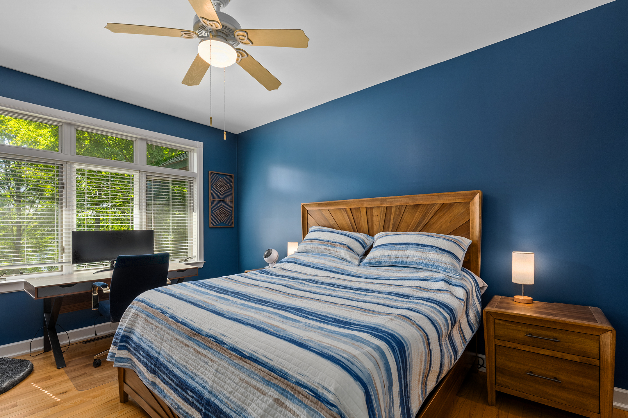 Cozy bedroom with comfortable queen bed and tranquil decor – rest well after your Northwoods adventures. One of four spacious bedrooms in the home.