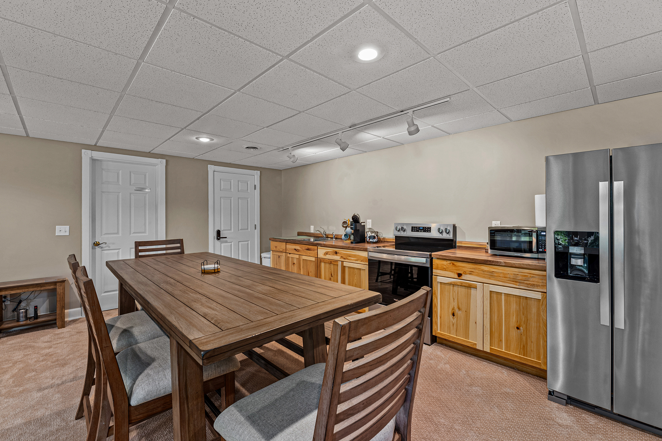 Lower-level kitchen and dining area – the home features TWO full kitchens including this downstairs kitchen with full appliances, perfect for large groups.