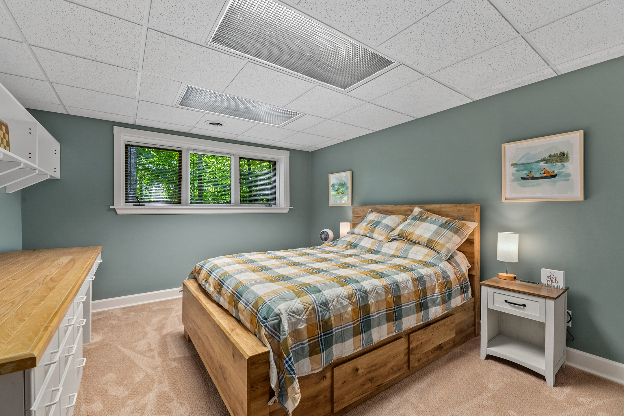 Lower-level bedroom with comfortable queen bed and natural light – sleeps two guests with privacy and comfort.