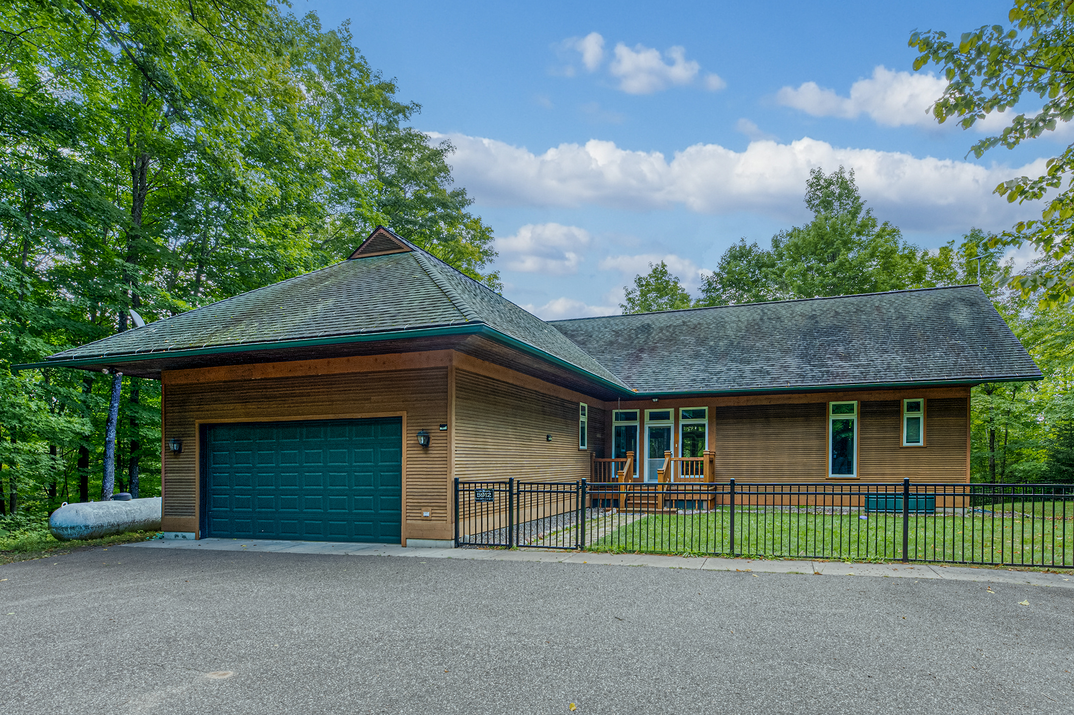 Charming lakeside cottage with attached garage – classic Northwoods architecture nestled in a private, wooded setting on Little Martha Lake.