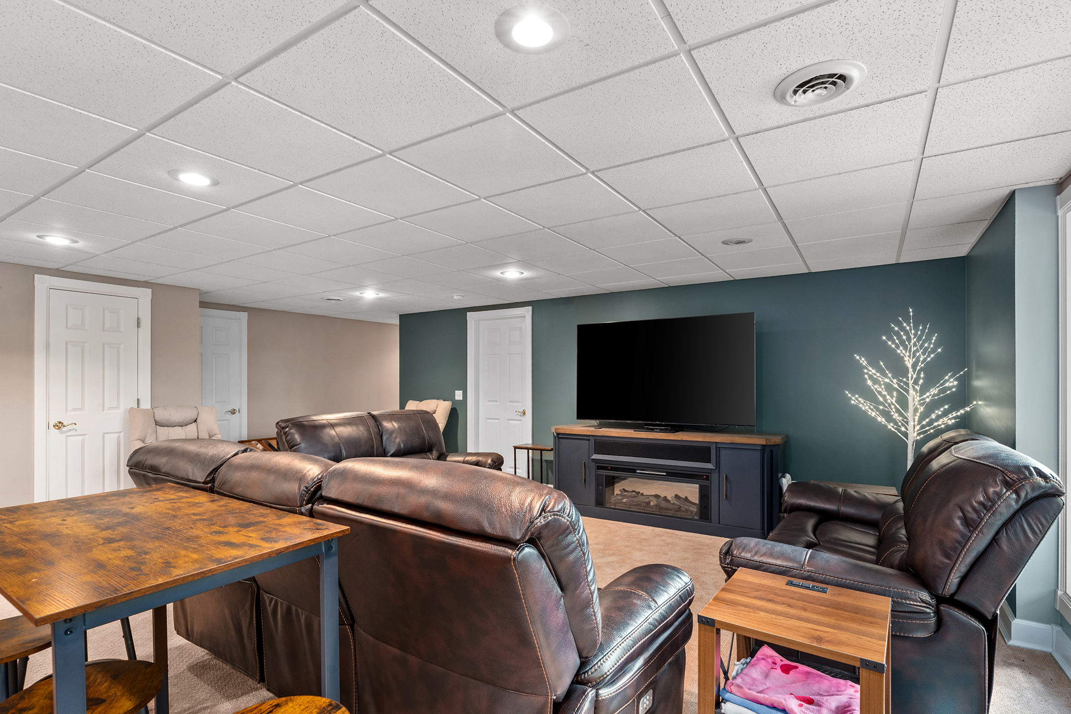 Lower-level entertainment area with big screen TV and comfortable sectional sofa – perfect for movie nights and relaxing after a day on the lake.