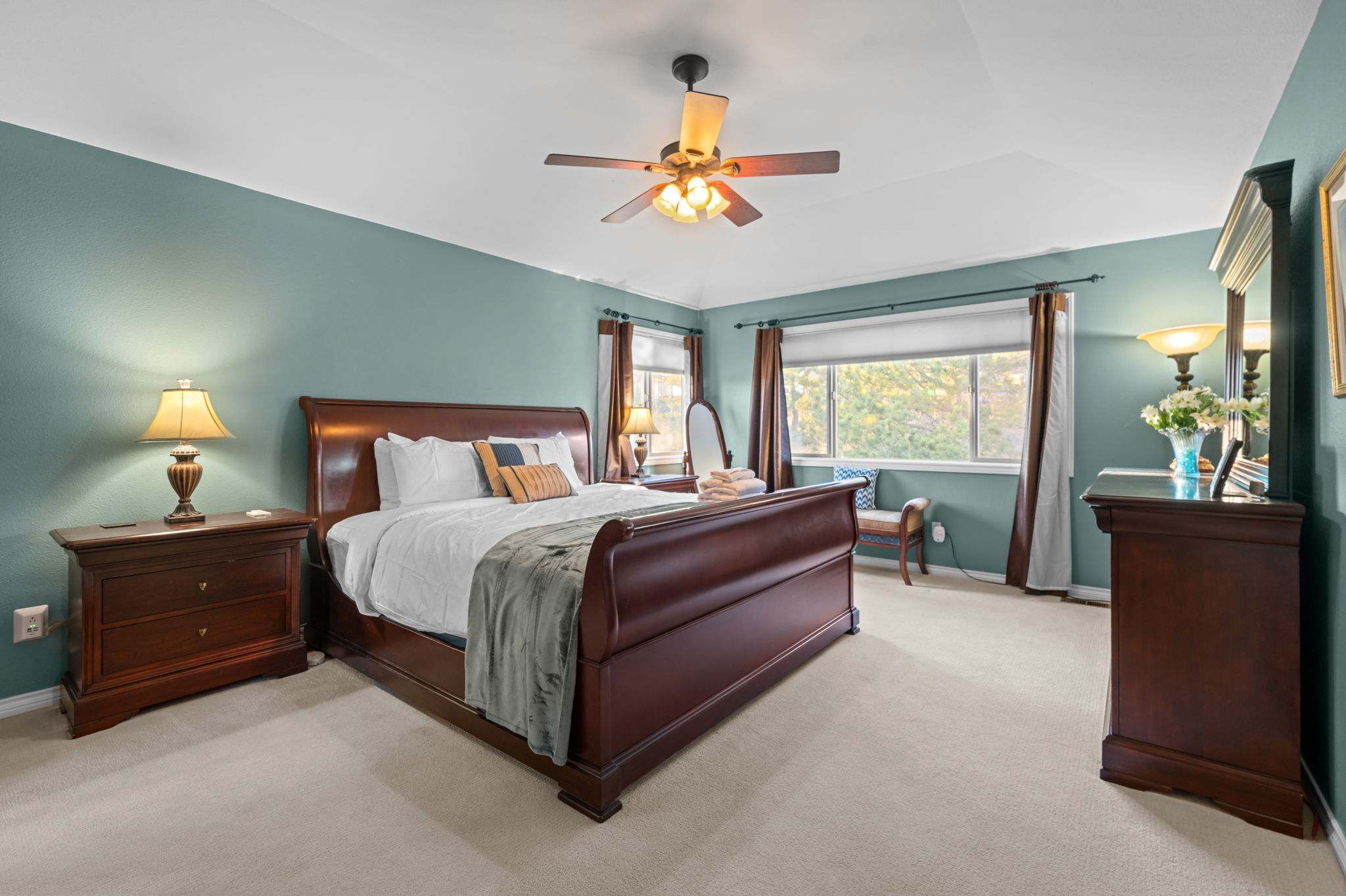 Primary bedroom with king bed, plush carpeting, and an ensuite bathroom.