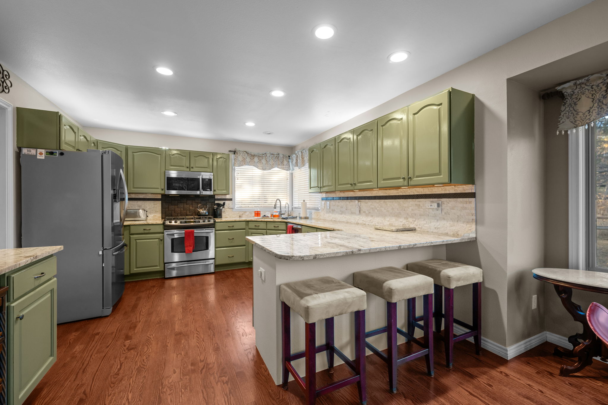 Sunny kitchen with granite countertops, modern appliances, and breakfast bar seating.Evening curb view showcasing the home''s inviting exterior and well-lit entryway.
