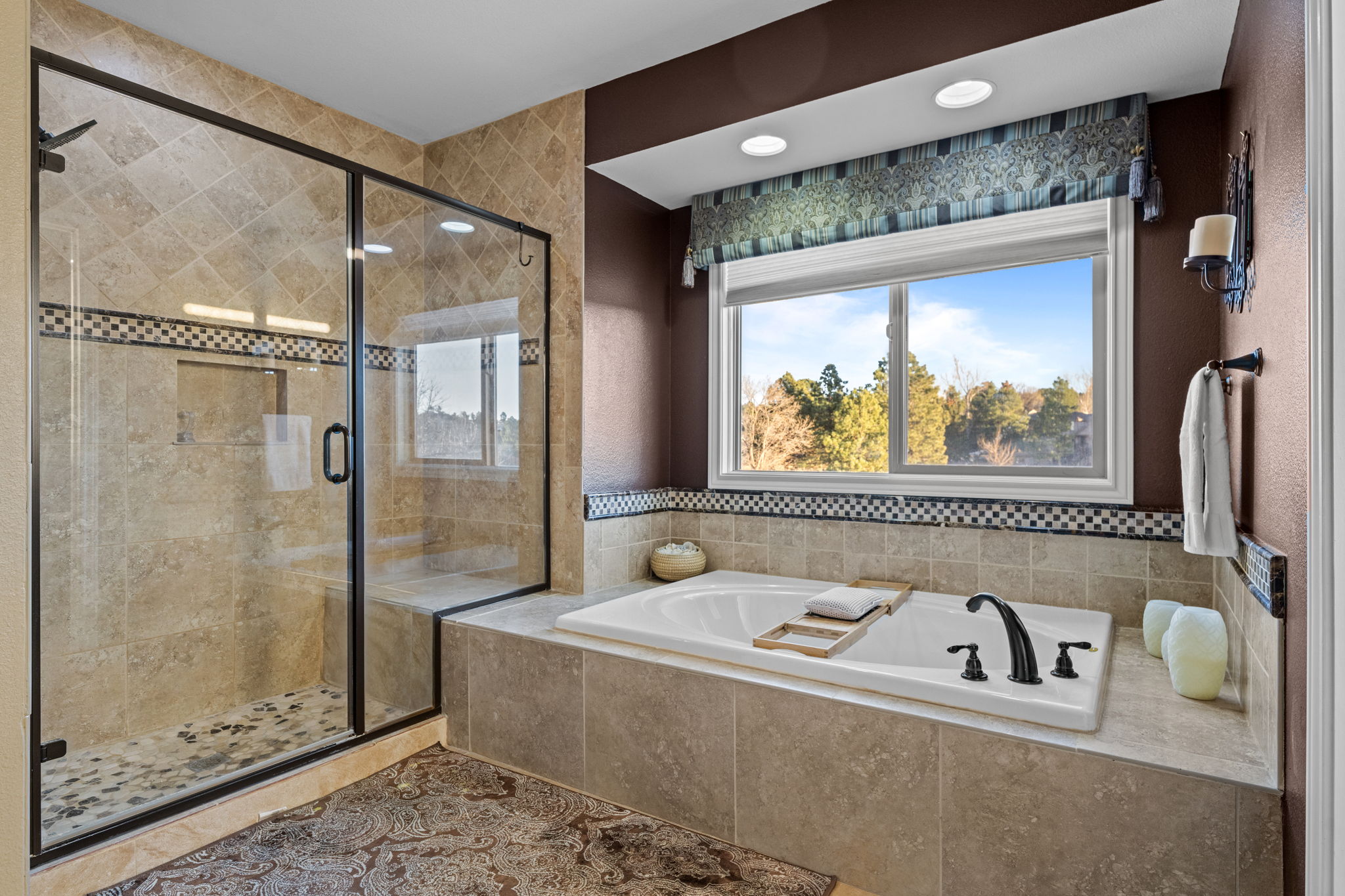 Luxurious primary bathroom with soaking tub, walk-in shower, and tile surround.