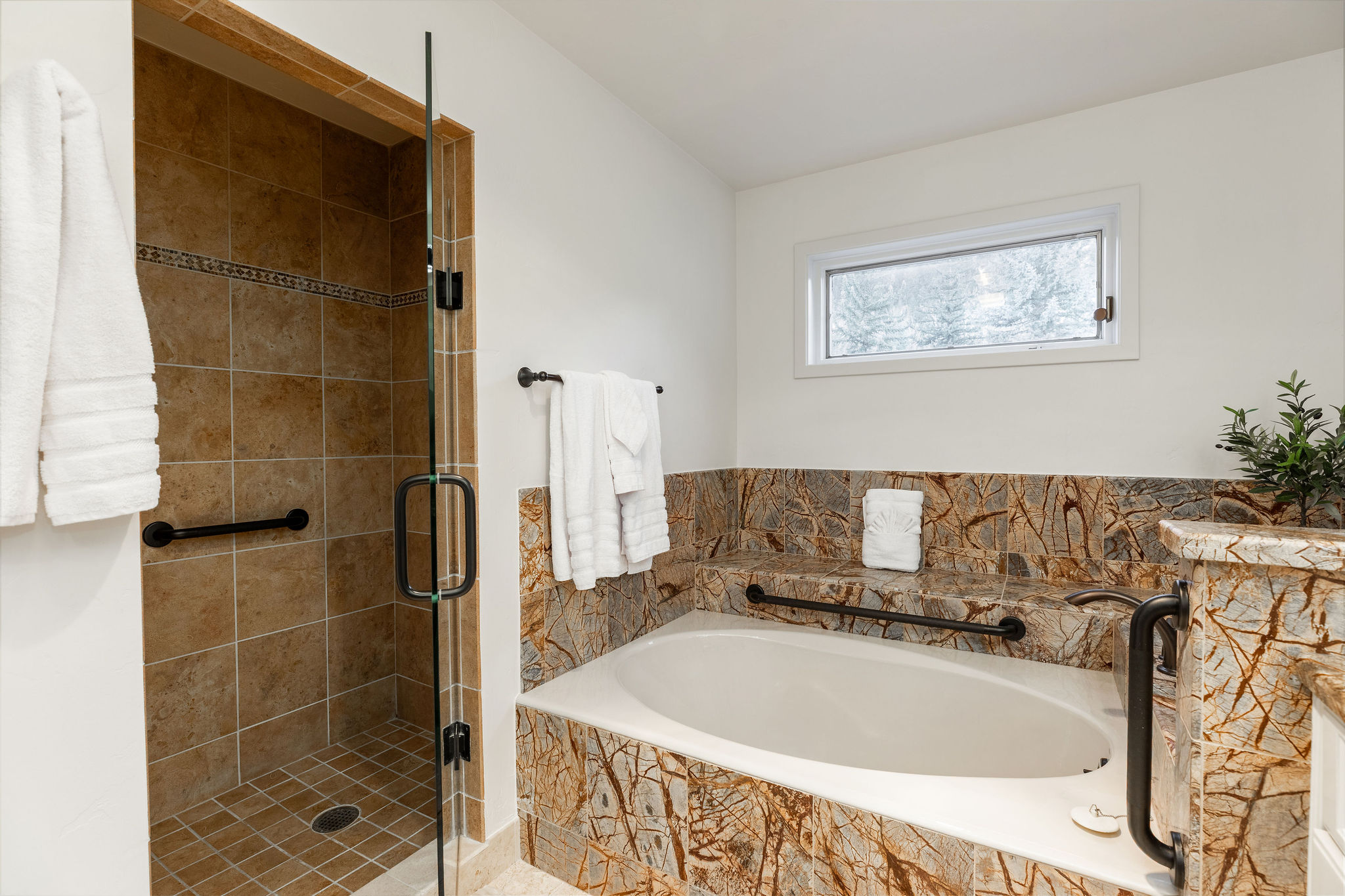 Full bathroom with dual vanities, a walk-in shower, and a soaking tub