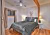 Second bedroom on the main level featuring a queen bed and a private half-bath ensuite.