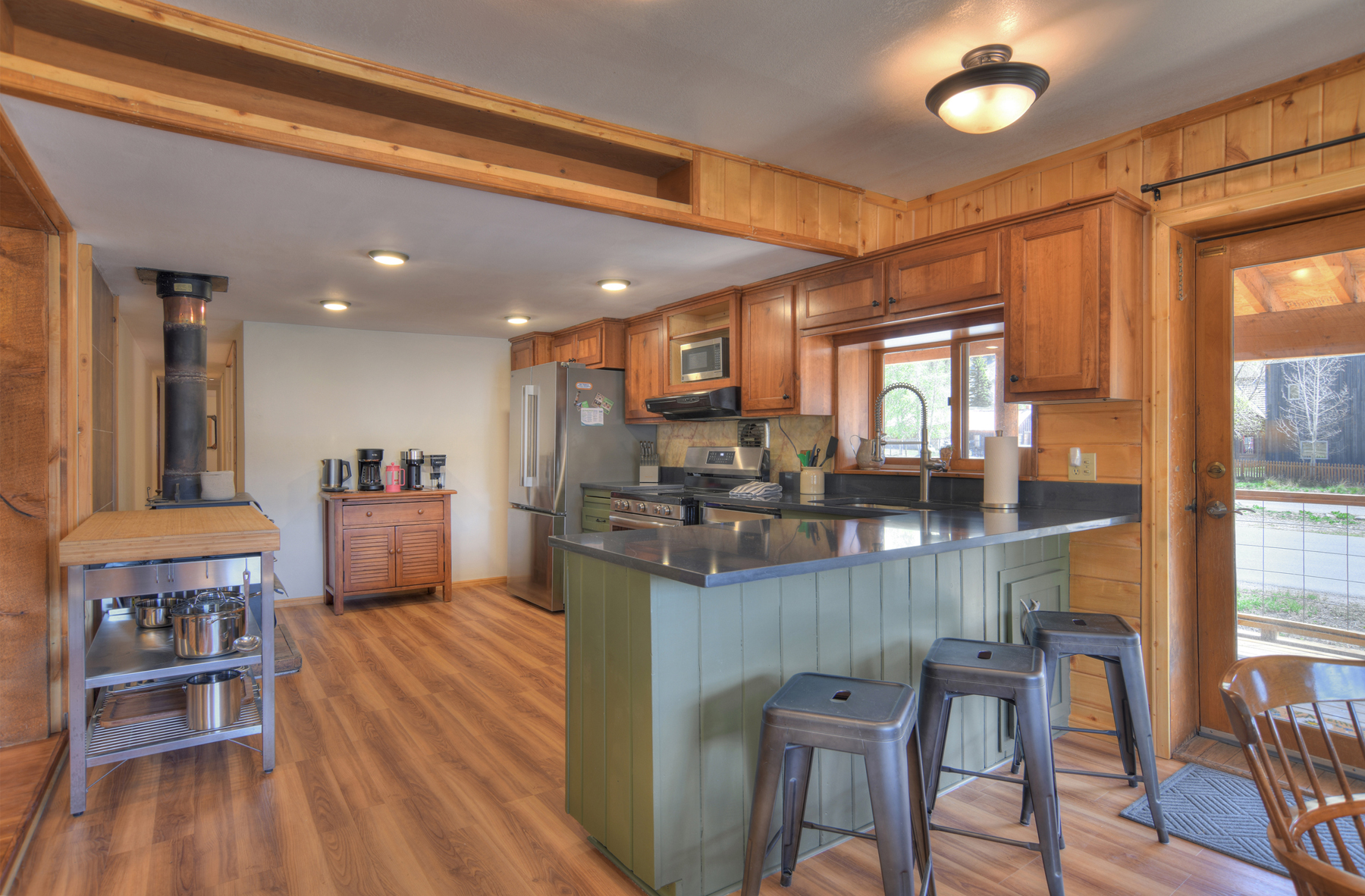 Open kitchen with stainless steel appliances and coffee bar.