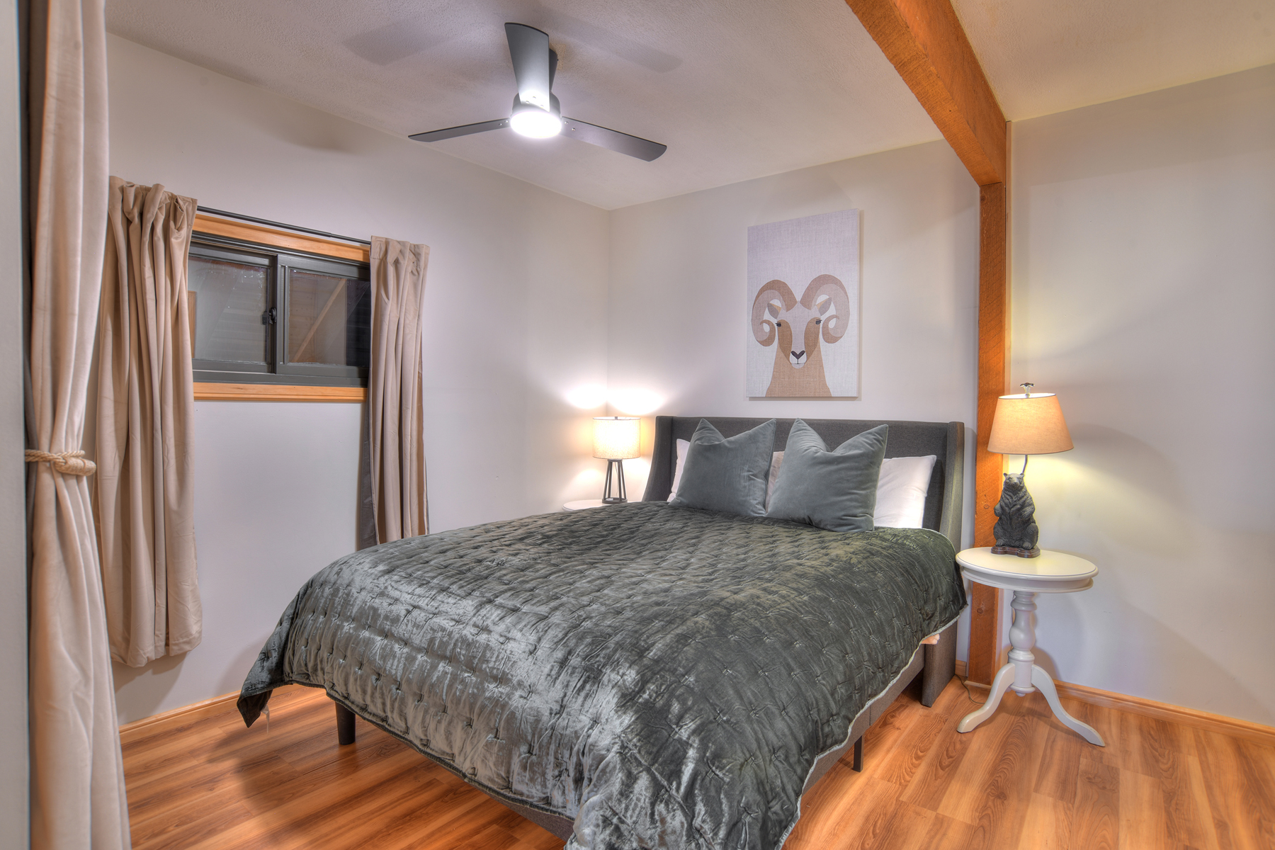 Second bedroom on the main level featuring a queen bed and a private half-bath ensuite.