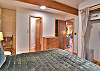 Second bedroom on the main level featuring a queen bed and a private half-bath ensuite.