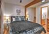 Second bedroom on the main level featuring a queen bed and a private half-bath ensuite.