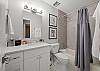 Full bathroom with convenient tub/shower combo and modern finishes.