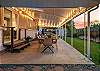 Covered patio with a dining table that seats 12, outdoor lounge seating, and games
