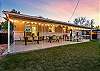 Covered patio with a dining table that seats 12, outdoor lounge seating, and games