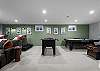 The basement theater/game room includes a big screen, comfortable seating + fooseball, air hockey, and Skee-Ball