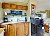 Kitchenette with small fridge, microwave, toaster, griddle, coffee maker, and outdoor grill for easy cooking indoors or out.