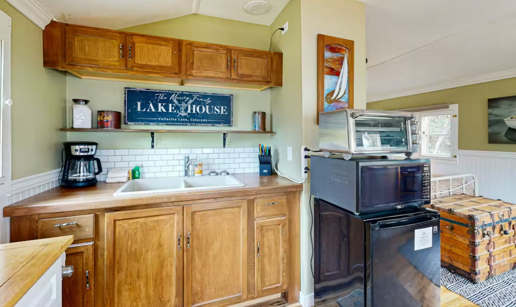 Kitchenette with small fridge, microwave, toaster, griddle, coffee maker, and outdoor grill for easy cooking indoors or out.