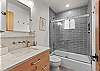 Full bathroom with convenient tub/shower combo and modern finishes.