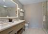 Full bathroom featuring a double vanity, large mirror, and a sleek walk-in shower.