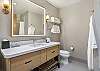 Clean and functional bathroom featuring a large mirror and a tub/shower combination.