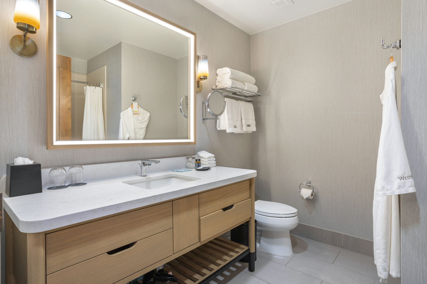 Clean and functional bathroom featuring a large mirror and a tub/shower combination.