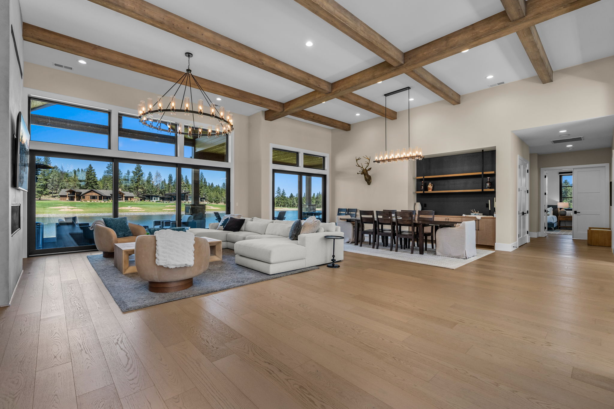 The open living room offers comfortable seating for the whole group, a gas fireplace, and Tanager Lake as the backdrop.