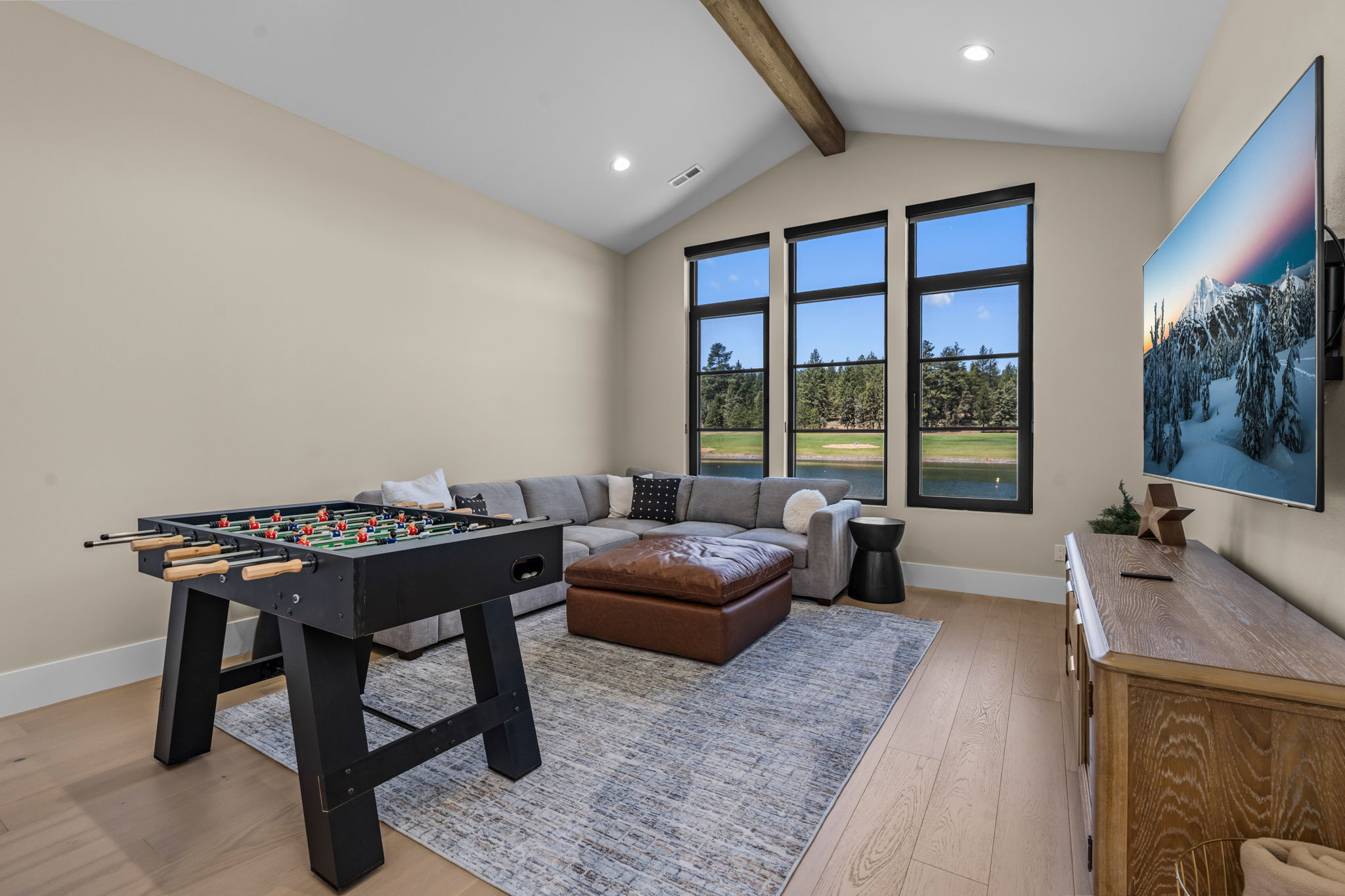 Game on. The media room features a queen sleeper sofa, large Smart TV, Xbox, and foosball table — the perfect wind-down after a day on the lake.