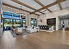 The open living room offers comfortable seating for the whole group, a gas fireplace, and Tanager Lake as the backdrop.