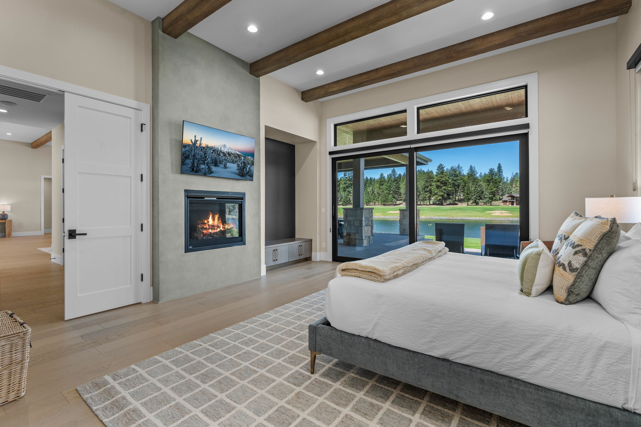 Wake up to sweeping Tanager Lake views — the primary suite features a king bed, gas fireplace, private patio access, and a spa-like ensuite with soaking tub, dual-head tiled shower, and walk-in closet.